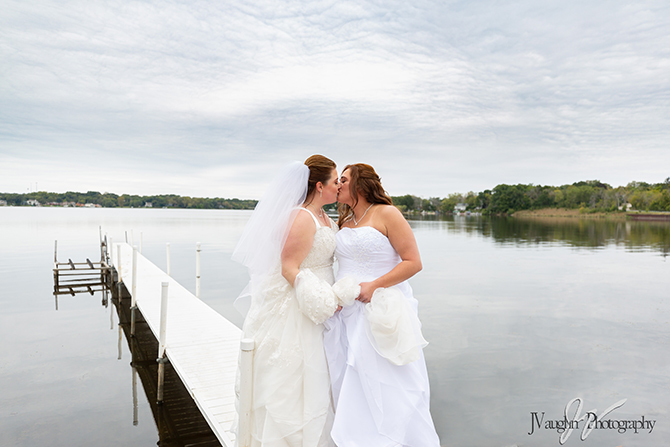 Lesbian brides on lake boat dock at Parkway Banquets