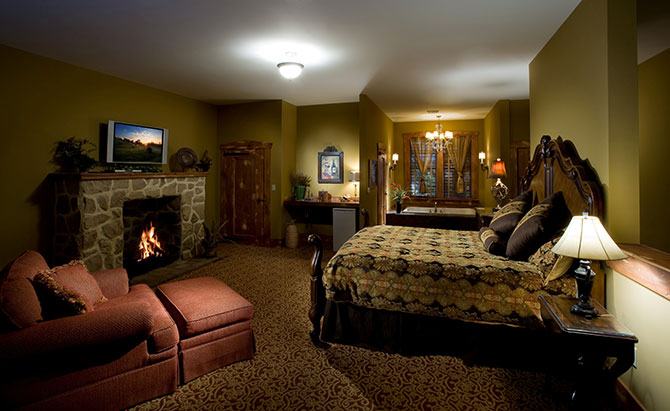 The Inn At Leola Village king guest room with stone fireplace