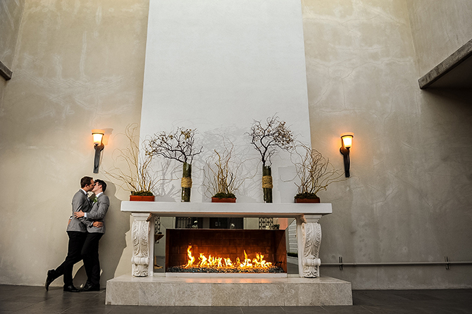 The R2 Studio Phoenix, Arizona grooms kissing by fireplace